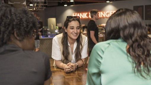 Three students sitting at a table chatting