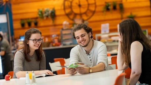 Three students inside café at Carmarthen campus
