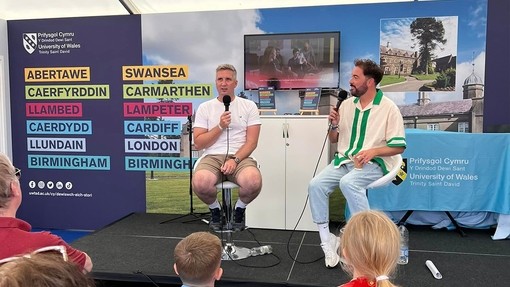 Musicians at the Eisteddfod with UWN banners in the background