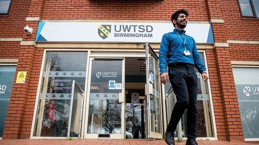 Student walking out from front of Birmingham campus