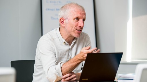 Staff member in discussion with laptop in front of him