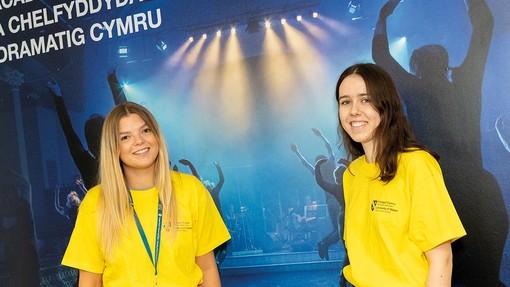 Student ambassadors standing in front of a WAVDA sign