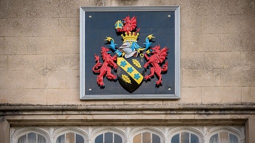 Brightly painted UWN coat-of-arms on the wall of the college in Lampeter.