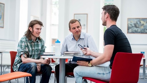 Three people in discussion at a table