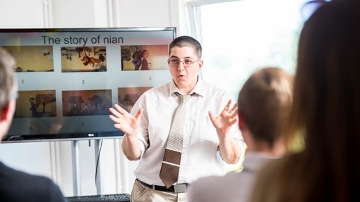 Lecturer presenting in front of a screen