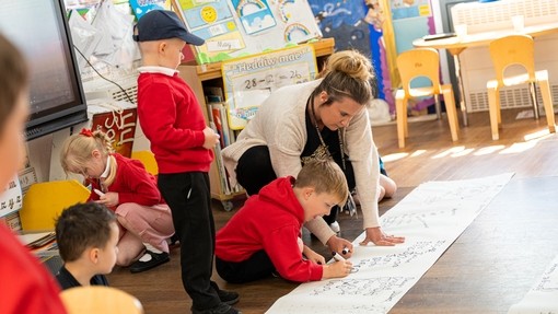 Primary teacher helping young student
