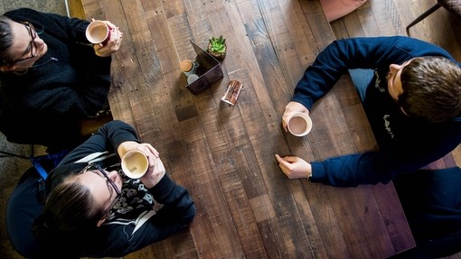 Three students enjoying a hot drink
