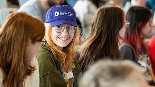 Student smiling and wearing a Students' Union cap